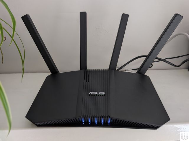 A black ASUS home Wi-Fi router with four antennas.